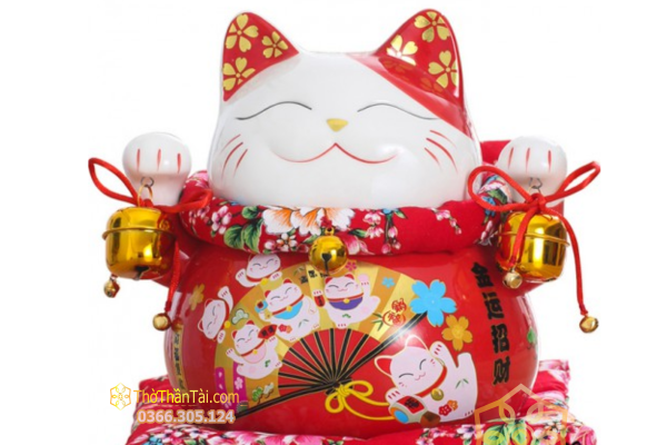 Mèo Thần Tài sứ đỏ đeo hai chuông vàng, bụng vẽ quạt giấy và hoa