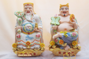 Tượng sứ Thần Tài cầm như ý và Ông Địa cầm quạt ngồi cạnh nhau