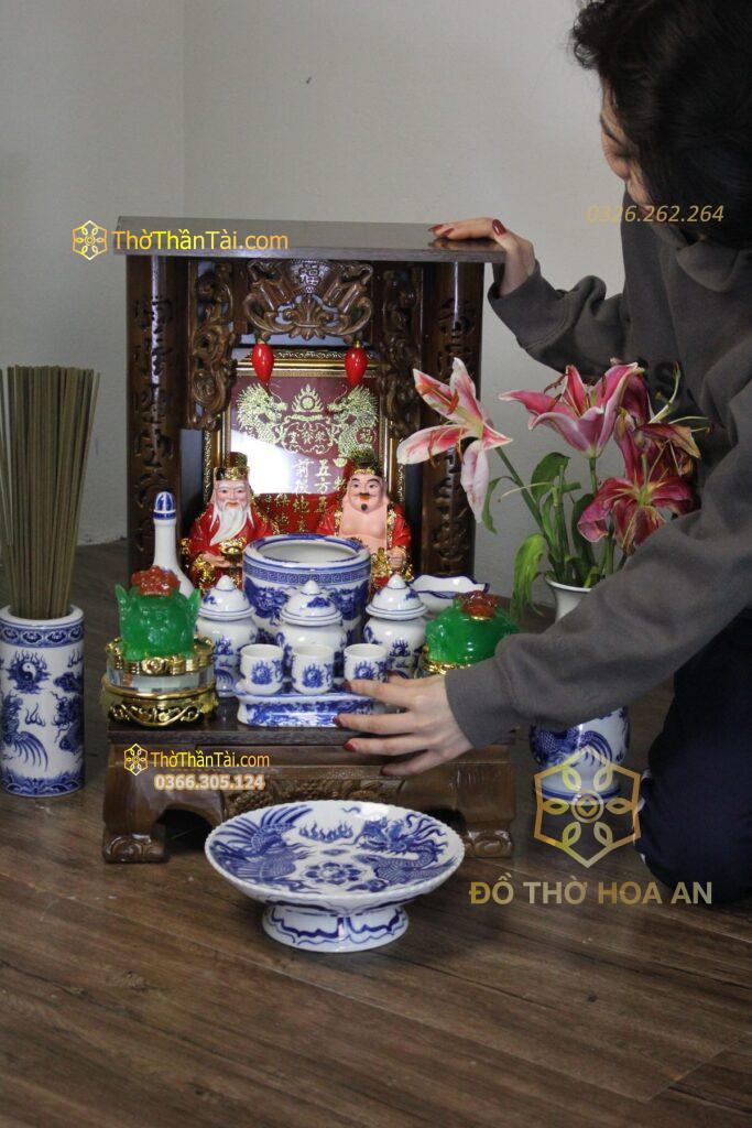 Ban thờ Thần Tài bày đủ bộ đồ thờ gồm bát hương, lọ hoa, mâm bồng và kỷ chén
